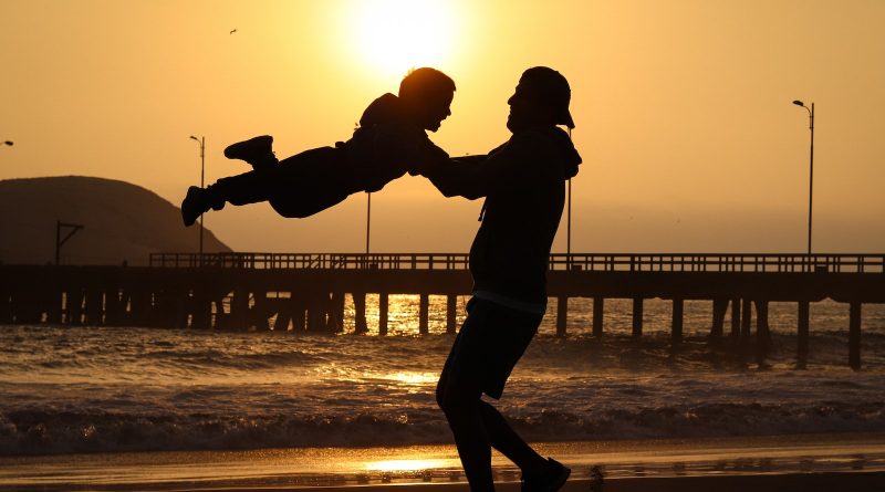Un père balance son enfant dans les airs.