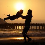 Un père balance son enfant dans les airs.