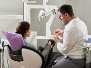 homme en chemise blanche assis sur une chaise de bureau noire à roulettes